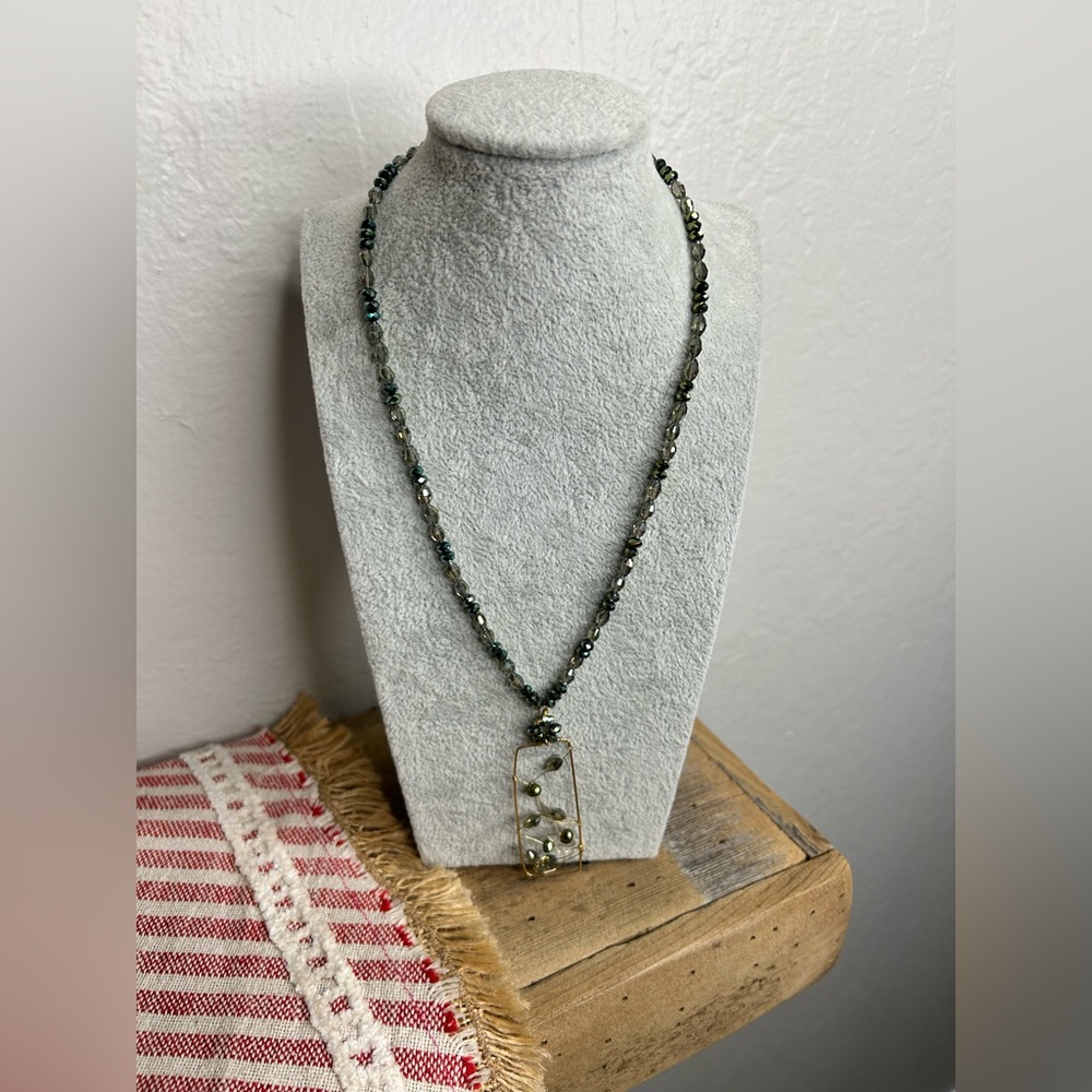 Glass beaded necklace with a unique gold tone wire-wrapped pendant.